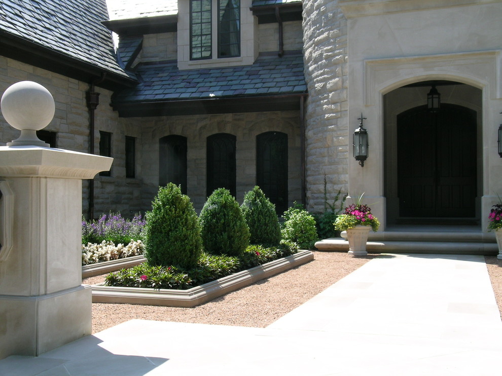 Expansive traditional beige house exterior in Chicago with stone veneer and a tile roof.