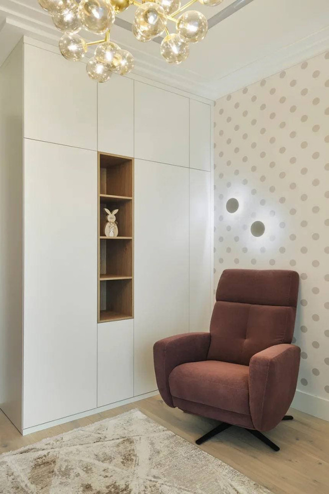 This is an example of a contemporary kids' room in Moscow with beige walls and light hardwood floors.