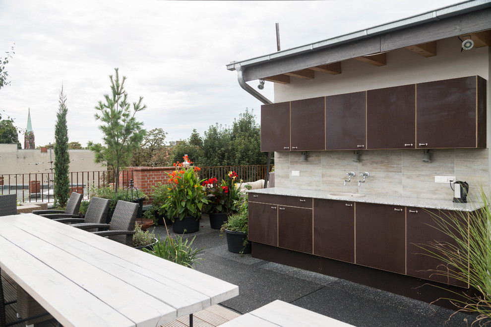 Contemporary deck in Berlin with an outdoor kitchen.