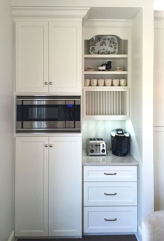 Inspiration for a large transitional galley light wood floor eat-in kitchen remodel in Chicago with a farmhouse sink, flat-panel cabinets, white cabinets, quartzite countertops, gray backsplash, stone slab backsplash, stainless steel appliances and an island