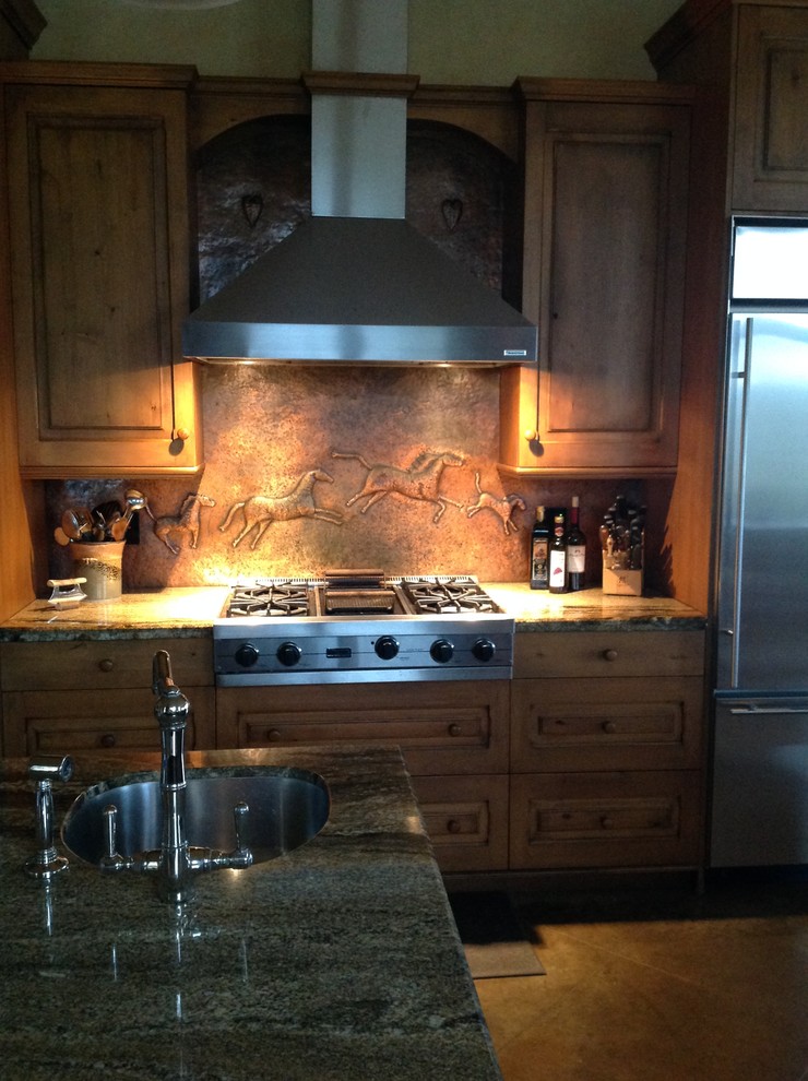 Inspiration for a transitional l-shaped concrete floor eat-in kitchen remodel in Austin with a single-bowl sink, raised-panel cabinets, medium tone wood cabinets, granite countertops, metallic backsplash, stainless steel appliances and white walls