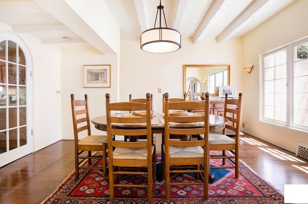 Mid-sized traditional separate dining room in Los Angeles with pink walls, laminate floors, no fireplace and brown floor.