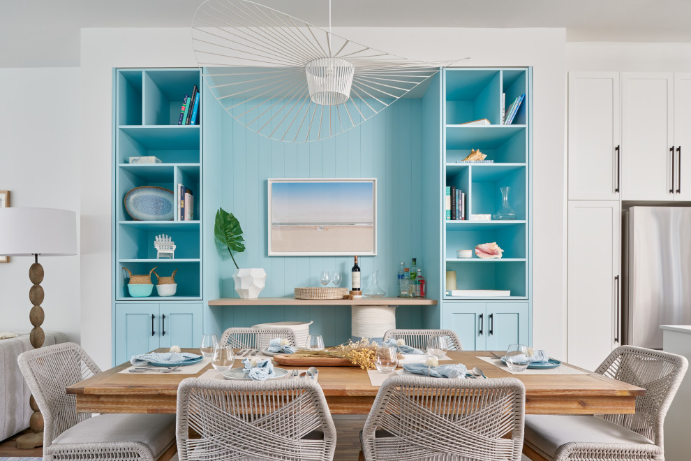 Foto di una sala da pranzo aperta verso la cucina chic di medie dimensioni con pareti bianche, parquet chiaro e pareti in perlinato