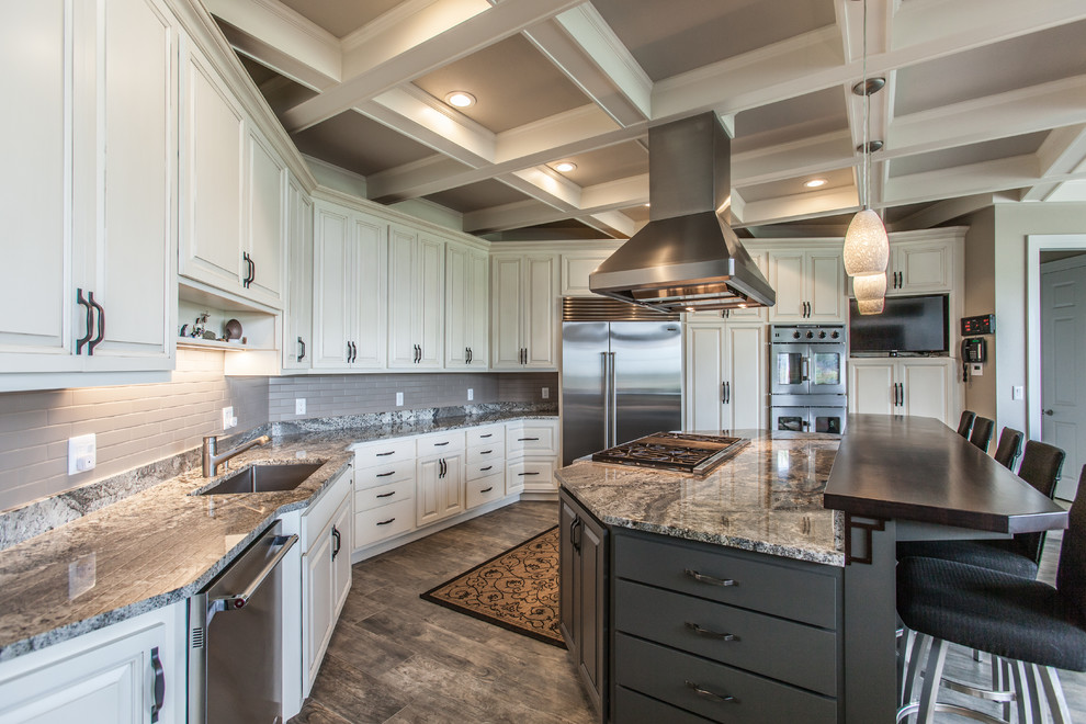 Design ideas for an expansive transitional eat-in kitchen in Chicago with an undermount sink, raised-panel cabinets, white cabinets, granite benchtops, stainless steel appliances, porcelain floors, with island, grey floor and subway tile splashback.