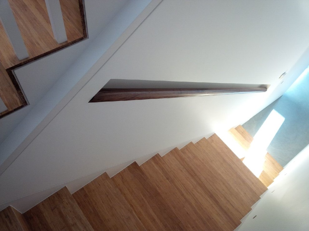 Small modern wood curved staircase in London with wood risers.