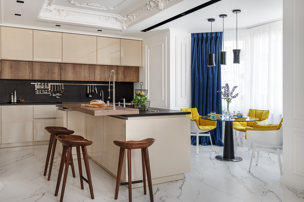 Design ideas for a contemporary eat-in kitchen in Moscow with flat-panel cabinets, beige cabinets, black splashback, stone slab splashback, with island, white floor and black benchtop.