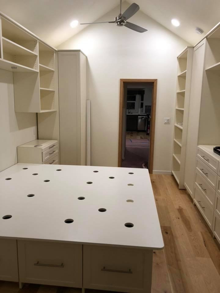 Mid-sized traditional gender-neutral walk-in wardrobe in Other with shaker cabinets, beige cabinets, medium hardwood floors and yellow floor.