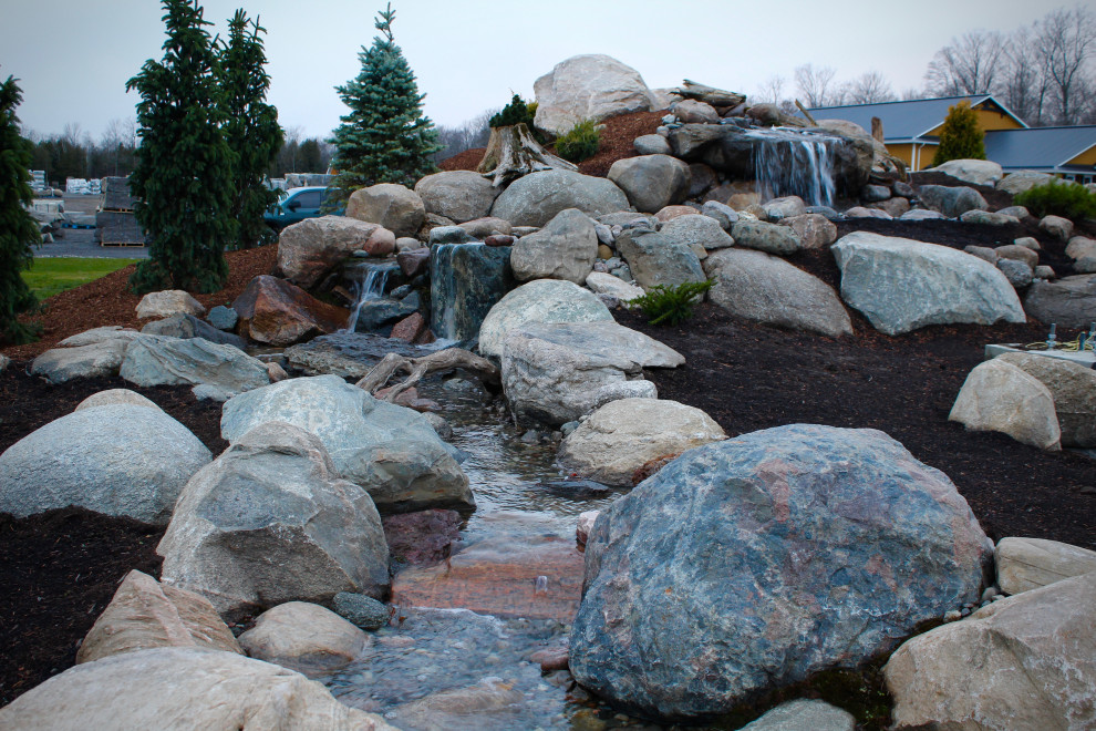 Inspiration for a huge rustic full sun hillside waterfall.