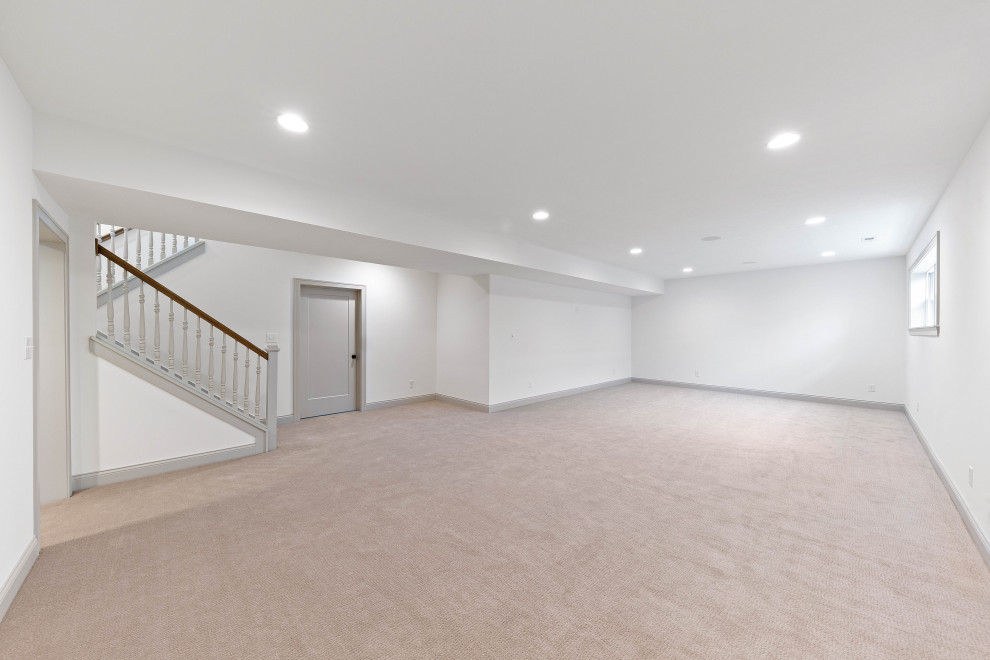 This is an example of a large traditional look-out basement in Indianapolis with white walls, carpet and grey floors.