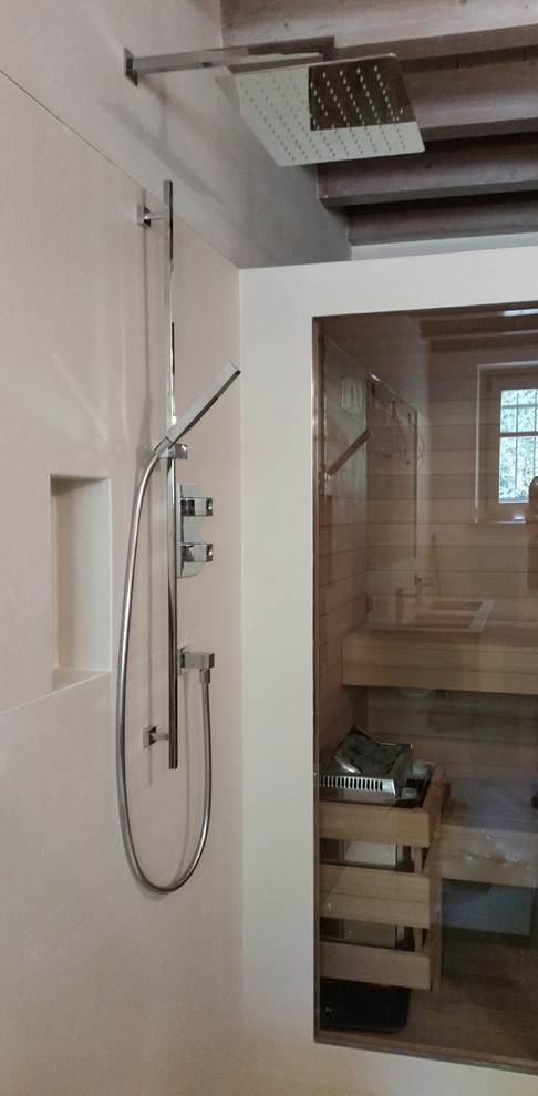 Photo of a small contemporary bathroom in Other with a curbless shower, a wall-mount toilet, white tile, porcelain tile, white walls, porcelain floors, with a sauna, white floor and a hinged shower door.
