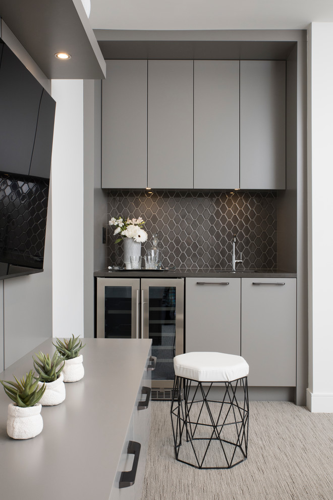 Photo of a small contemporary galley wet bar in Vancouver with an undermount sink, flat-panel cabinets, grey cabinets, quartzite benchtops, grey splashback, porcelain splashback, carpet, grey floor and grey benchtop.