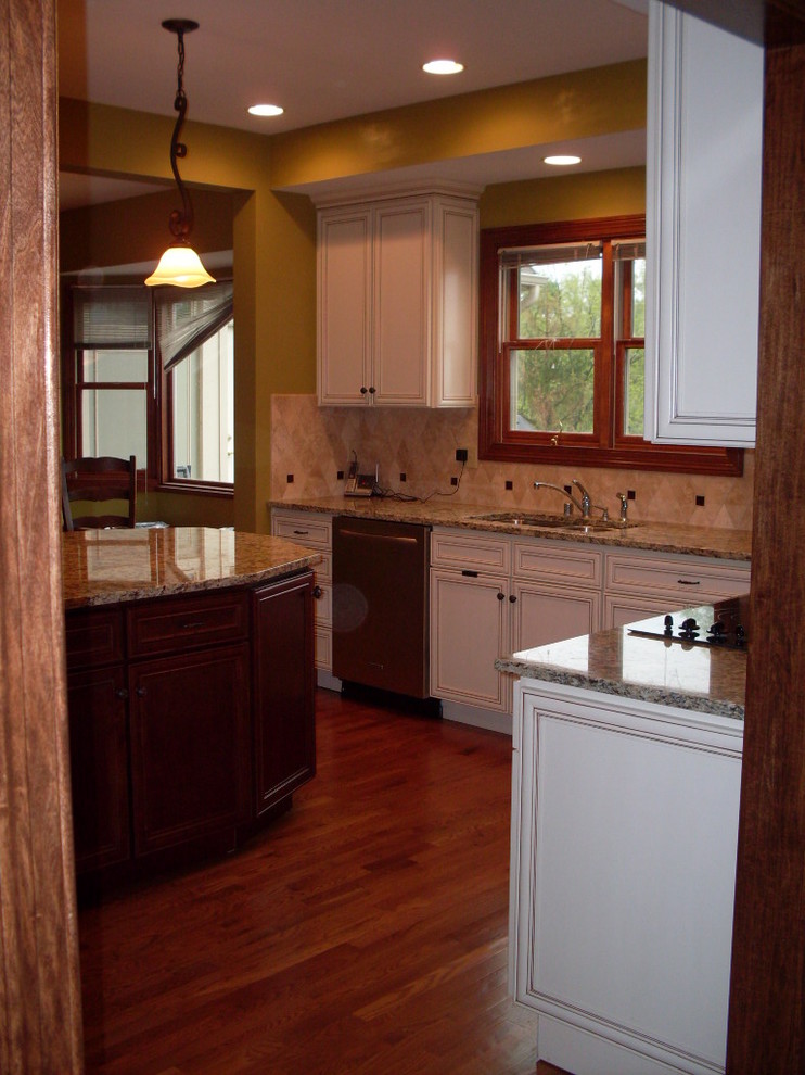 Open concept kitchen - mid-sized transitional u-shaped dark wood floor open concept kitchen idea in Cincinnati with an undermount sink, recessed-panel cabinets, white cabinets, granite countertops, beige backsplash, ceramic backsplash, stainless steel appliances and an island
