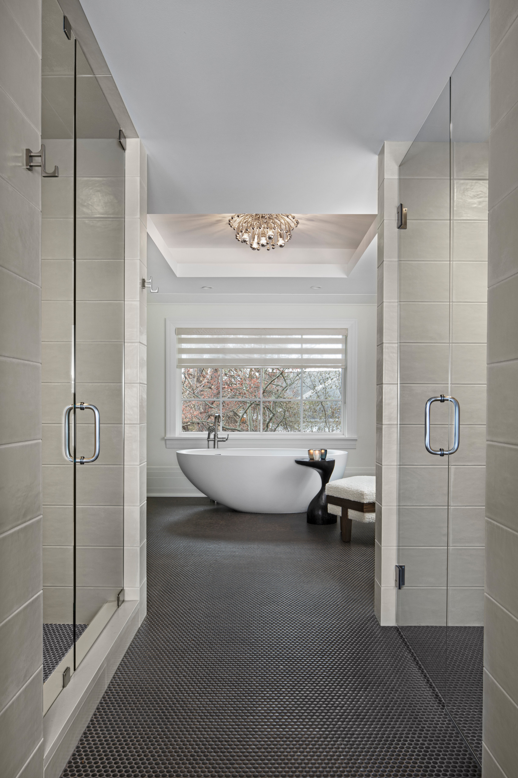 The experience of entering the master bath for Her is one filled with elegance and drama. The copper penny round tile floor leads past a pair of Euro Glass doors, with a shower room to the left and a
