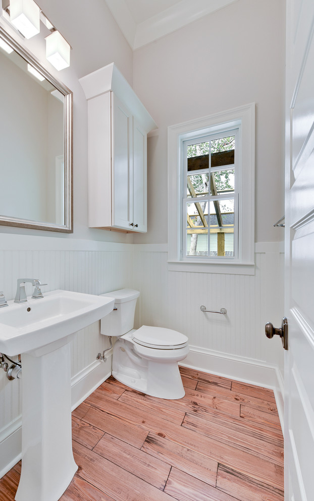 Design ideas for a mid-sized country 3/4 bathroom in New Orleans with a one-piece toilet, grey walls, dark hardwood floors, a pedestal sink and brown floor.