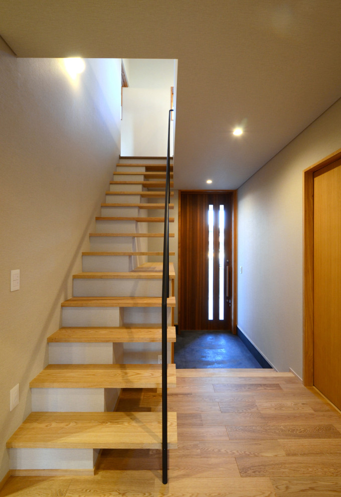 На фото: лестница среднего размера в восточном стиле с обоями на стенах с