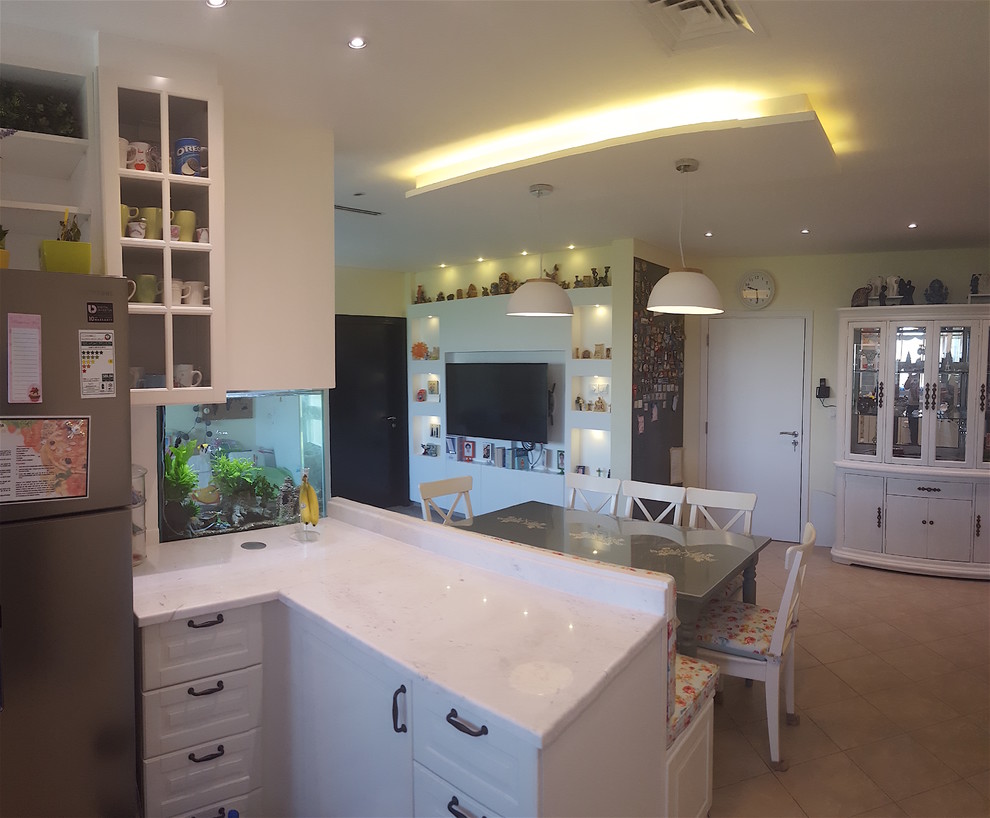 This is an example of a mid-sized contemporary u-shaped eat-in kitchen in Other with a single-bowl sink, louvered cabinets, white cabinets, marble benchtops, blue splashback, ceramic splashback, stainless steel appliances and no island.