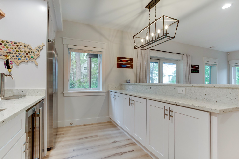 Example of a large beach style l-shaped wet bar design in Baltimore with an undermount sink, recessed-panel cabinets, wood countertops, white backsplash and subway tile backsplash
