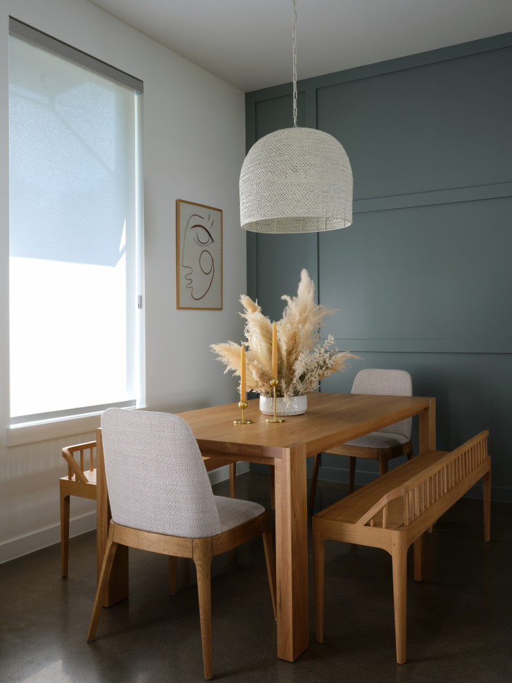 Réalisation d'une petite salle à manger nordique avec une banquette d'angle, un mur bleu, sol en béton ciré et un sol marron.