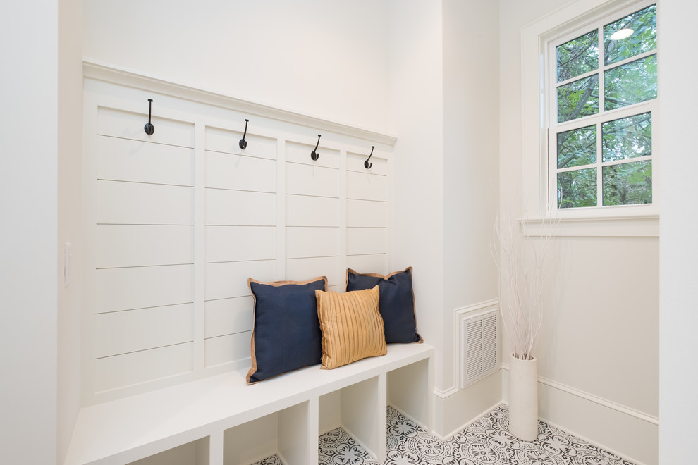 Design ideas for a mid-sized eclectic mudroom in Charlotte with white walls and ceramic floors.