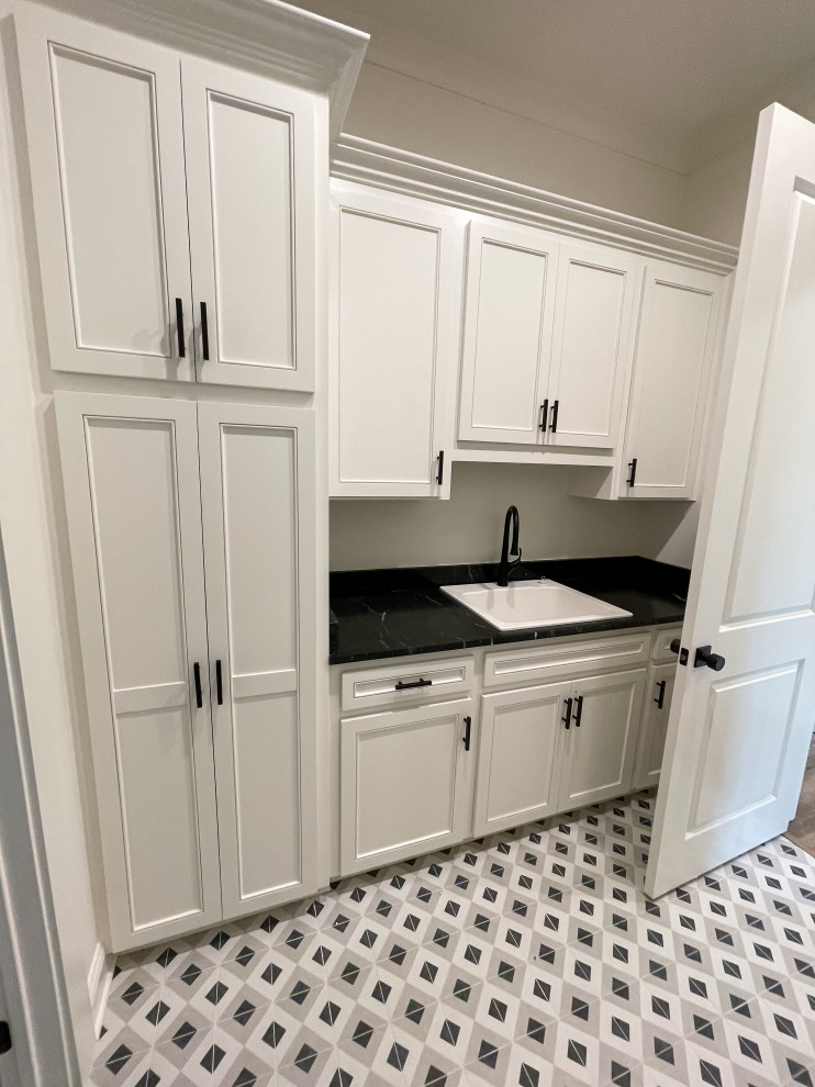 Design ideas for an expansive contemporary dedicated laundry room in New Orleans with a drop-in sink, shaker cabinets, white cabinets, quartz benchtops, white splashback, subway tile splashback, blue walls, ceramic floors, a side-by-side washer and dryer, white floor and black benchtop.