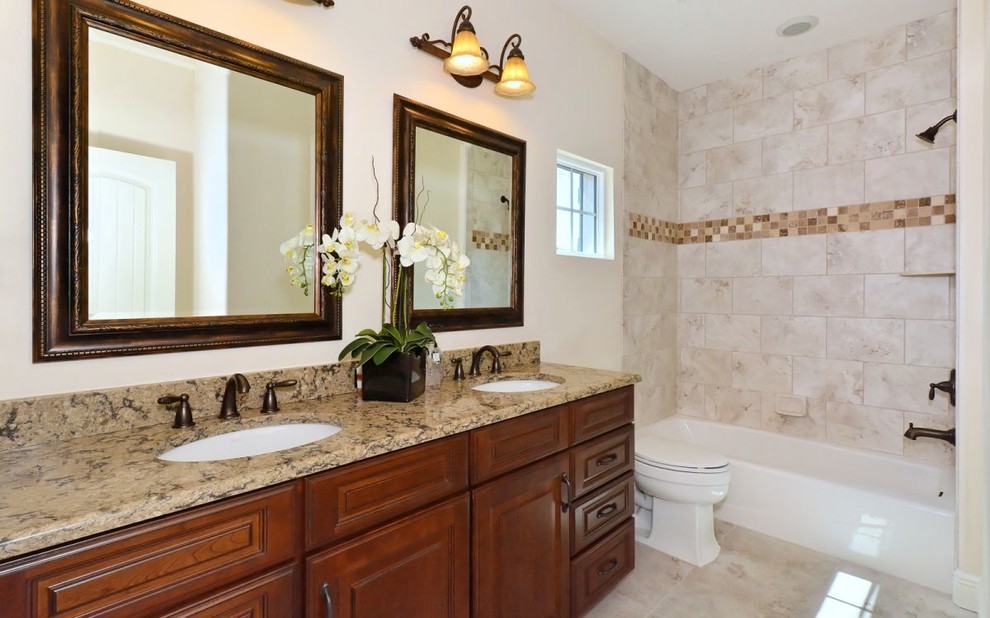 Mid-sized transitional kids bathroom in Tampa with an undermount sink, raised-panel cabinets, medium wood cabinets, engineered quartz benchtops, an alcove tub, a shower/bathtub combo, beige tile, porcelain tile, beige walls and porcelain floors.