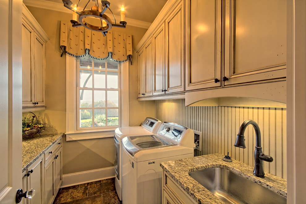 This is an example of a mid-sized country galley dedicated laundry room in Atlanta with an undermount sink, recessed-panel cabinets, granite benchtops, beige walls, porcelain floors, a side-by-side washer and dryer and beige cabinets.