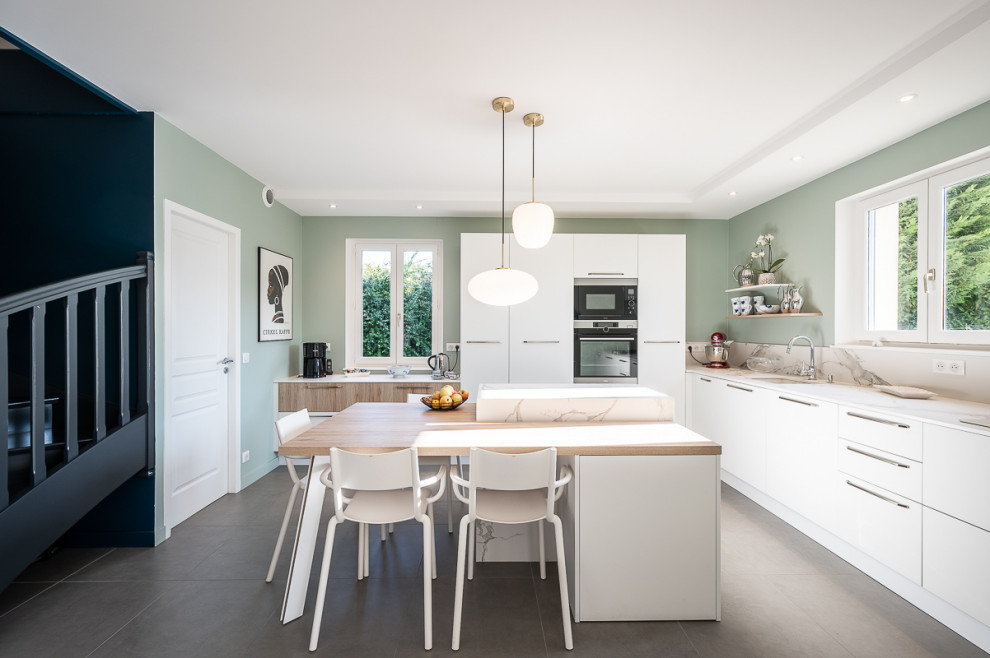 Inspiration for a large scandinavian l-shaped open plan kitchen in Lyon with an integrated sink, flat-panel cabinets, white cabinets, marble benchtops, marble splashback, stainless steel appliances, ceramic floors, with island and grey floor.