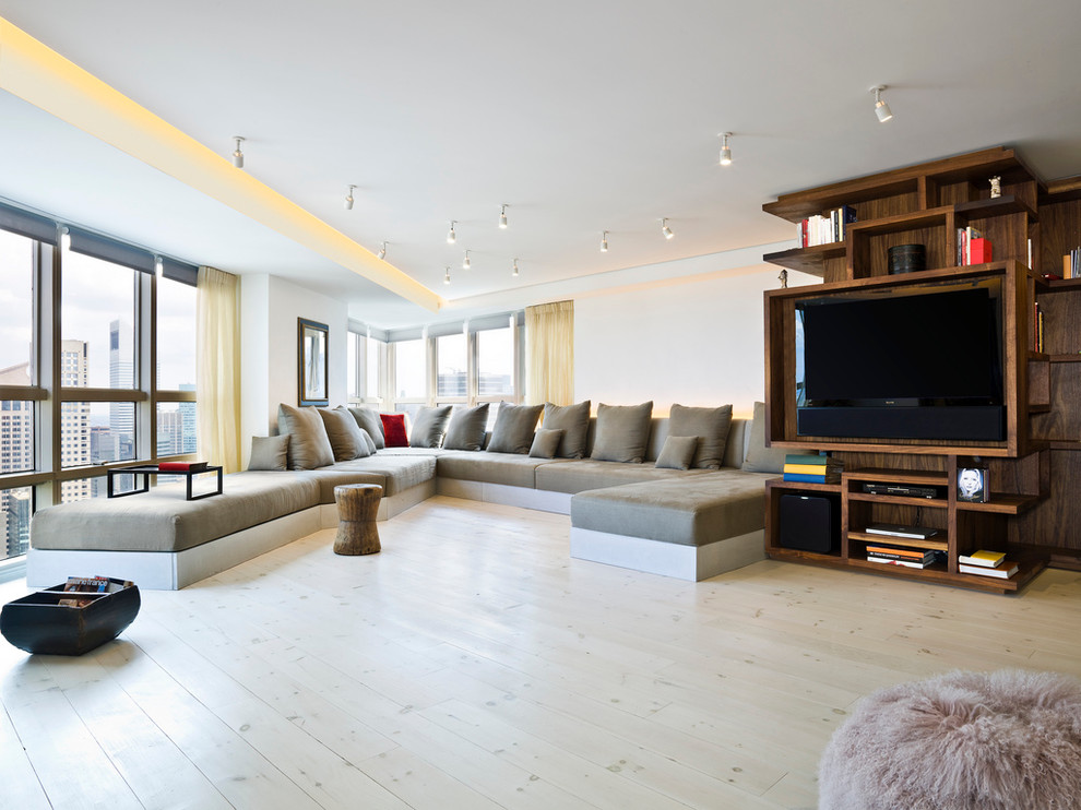 This is an example of a contemporary living room in New York with white walls and a built-in media wall.