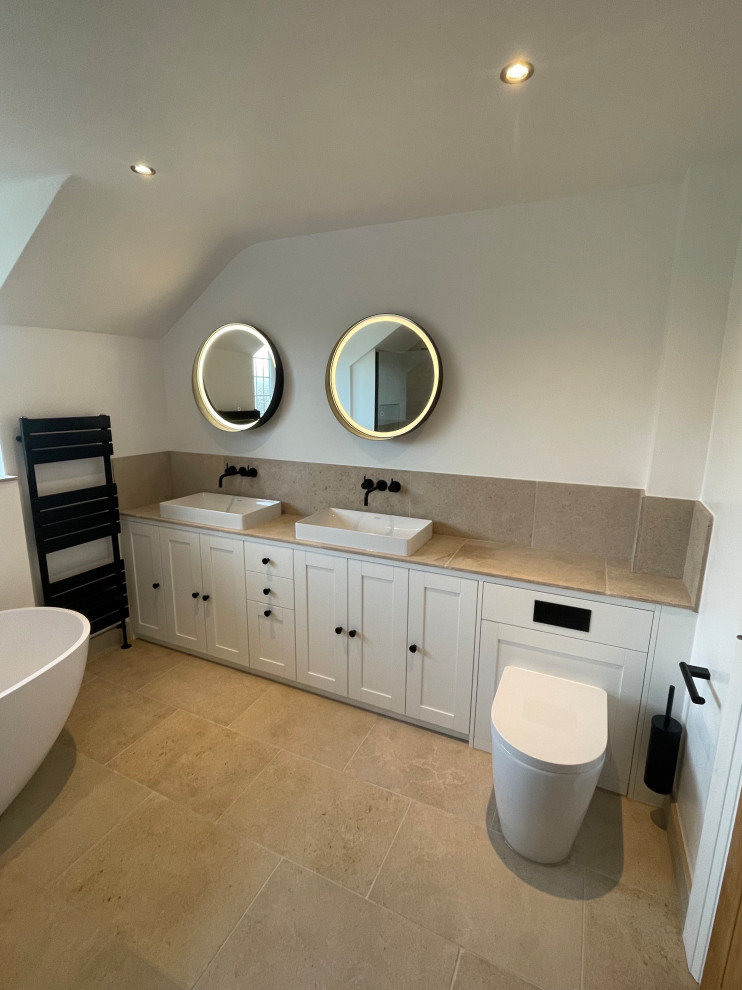 Photo of a large modern family bathroom in Oxfordshire with shaker cabinets, a freestanding bath, a walk-in shower, a one-piece toilet, travertine flooring, a vessel sink, tiled worktops, an open shower and a built in vanity unit.