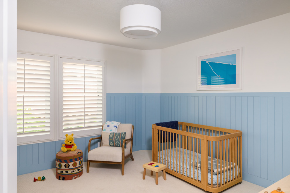 Inspiration for a mid-sized transitional boy carpeted, beige floor and wainscoting nursery remodel in Orange County with blue walls