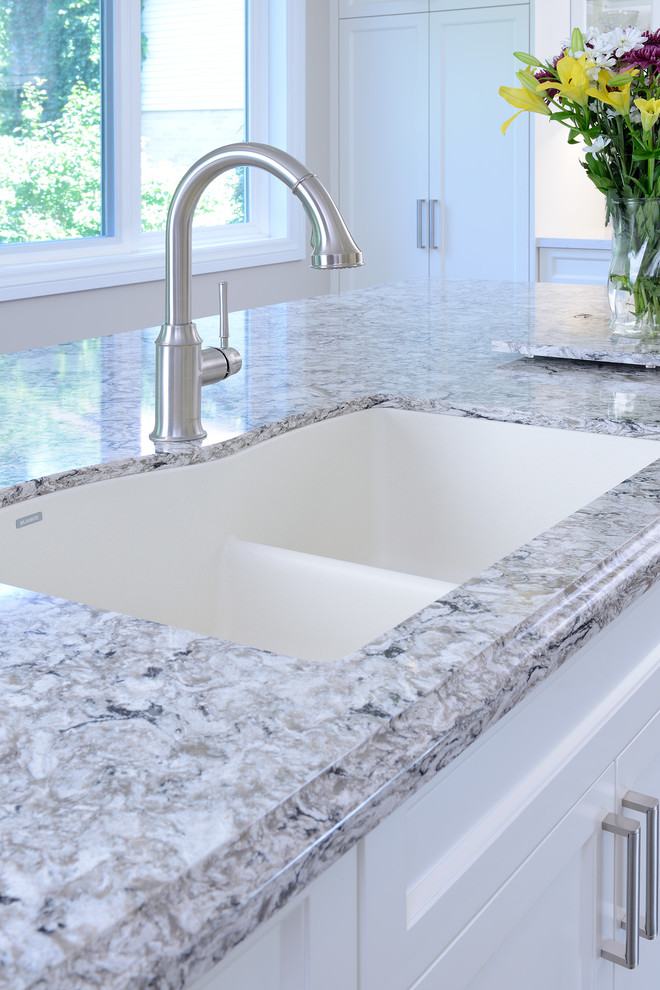 Example of a mid-sized transitional l-shaped medium tone wood floor and brown floor eat-in kitchen design in Toronto with an undermount sink, shaker cabinets, white cabinets, quartz countertops, white backsplash, subway tile backsplash, stainless steel appliances and an island
