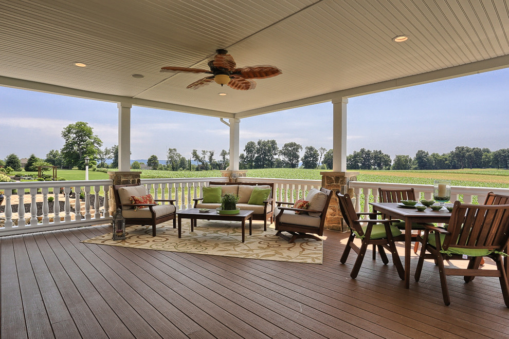Inspiration for a transitional backyard deck remodel with a roof extension