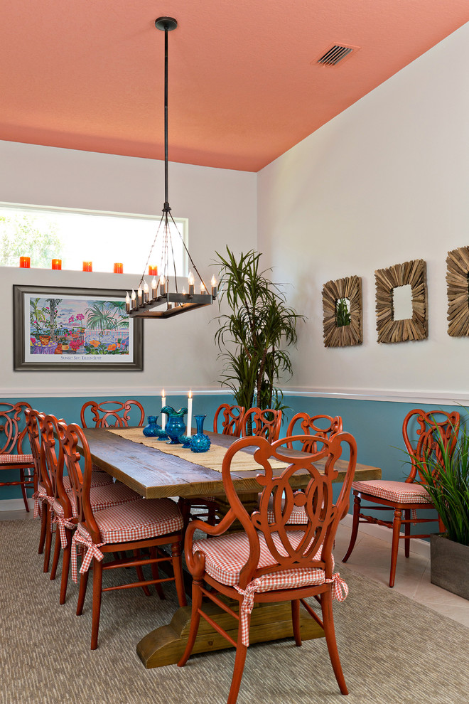 This is an example of a tropical dining room in Miami with white walls.