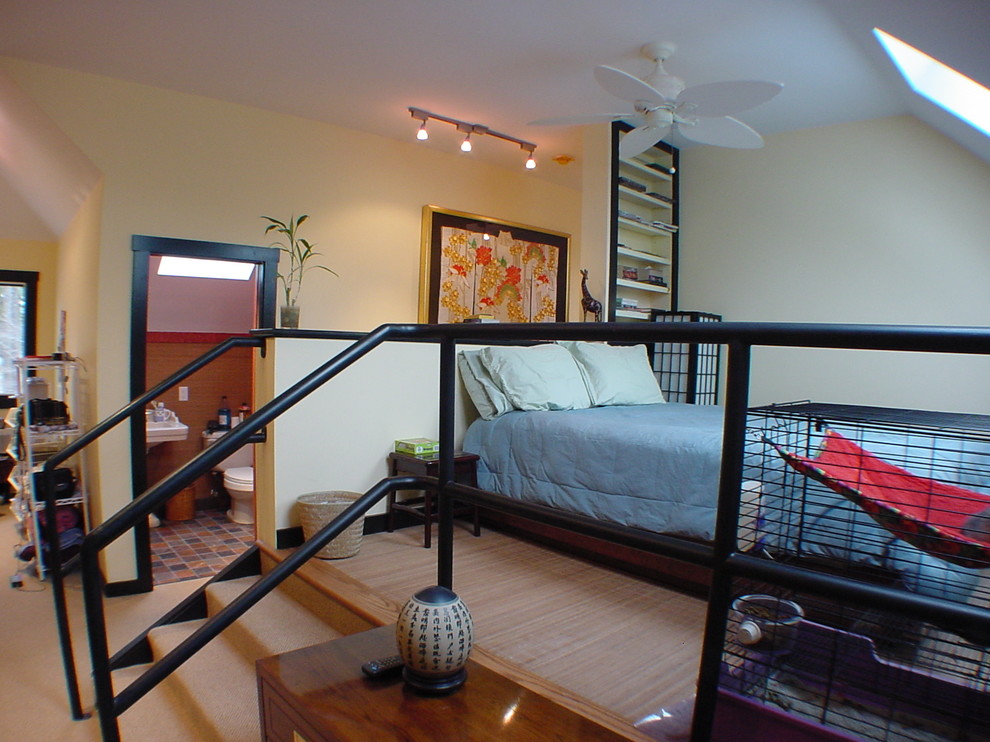 This is an example of a small transitional loft-style bedroom in Atlanta with yellow walls and carpet.
