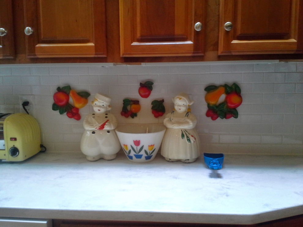 Example of a large mountain style l-shaped eat-in kitchen design with raised-panel cabinets, medium tone wood cabinets, solid surface countertops, an island, white backsplash and ceramic backsplash
