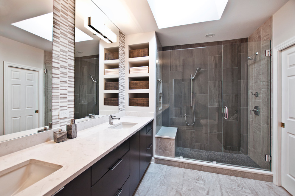 Photo of a large contemporary master bathroom in Nashville with flat-panel cabinets, dark wood cabinets, an alcove shower, a two-piece toilet, gray tile, porcelain tile, grey walls, porcelain floors, engineered quartz benchtops and an undermount sink.