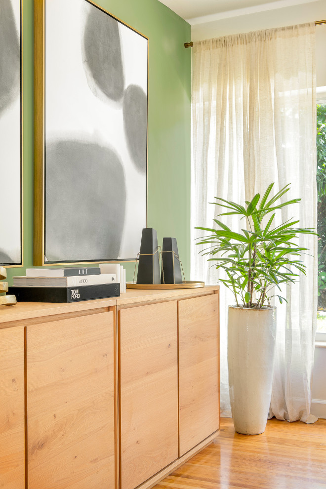 Mittelgroße Moderne Wohnküche ohne Kamin mit grüner Wandfarbe, hellem Holzboden und braunem Boden in Miami