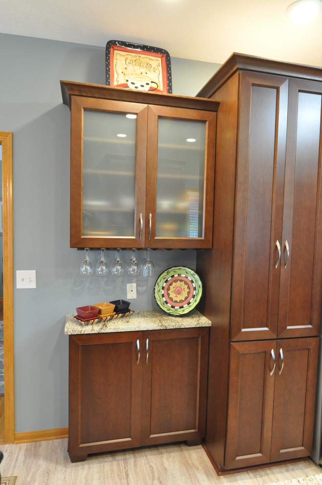 Inspiration for a mid-sized transitional u-shaped porcelain tile eat-in kitchen remodel with an undermount sink, recessed-panel cabinets, dark wood cabinets, granite countertops, beige backsplash and stainless steel appliances