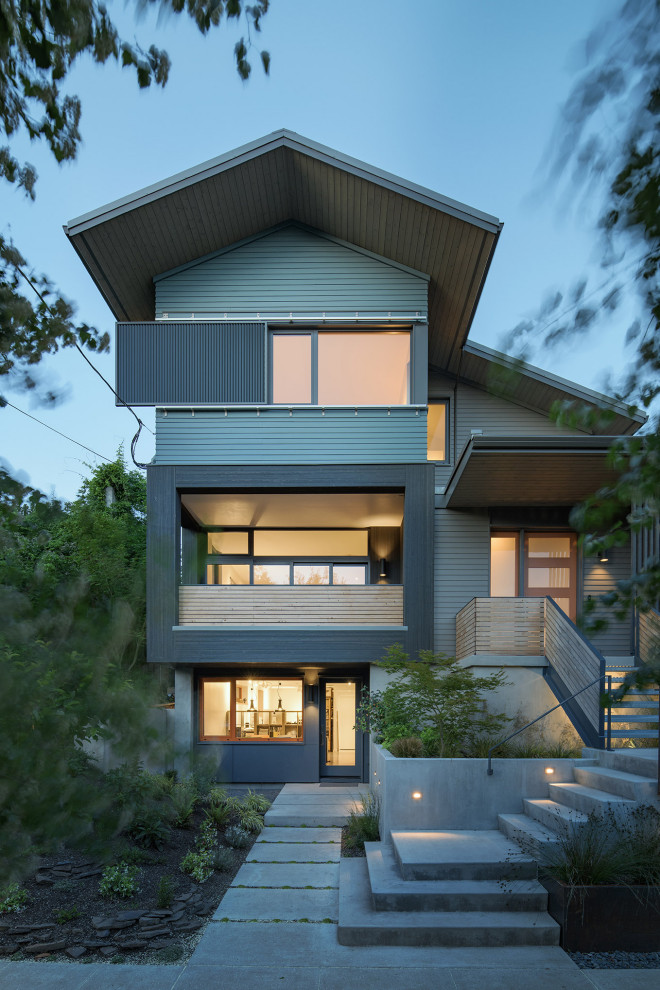 Свежая идея для дизайна: трехэтажный, синий частный загородный дом среднего размера в современном стиле с отделкой планкеном - отличное фото интерьера