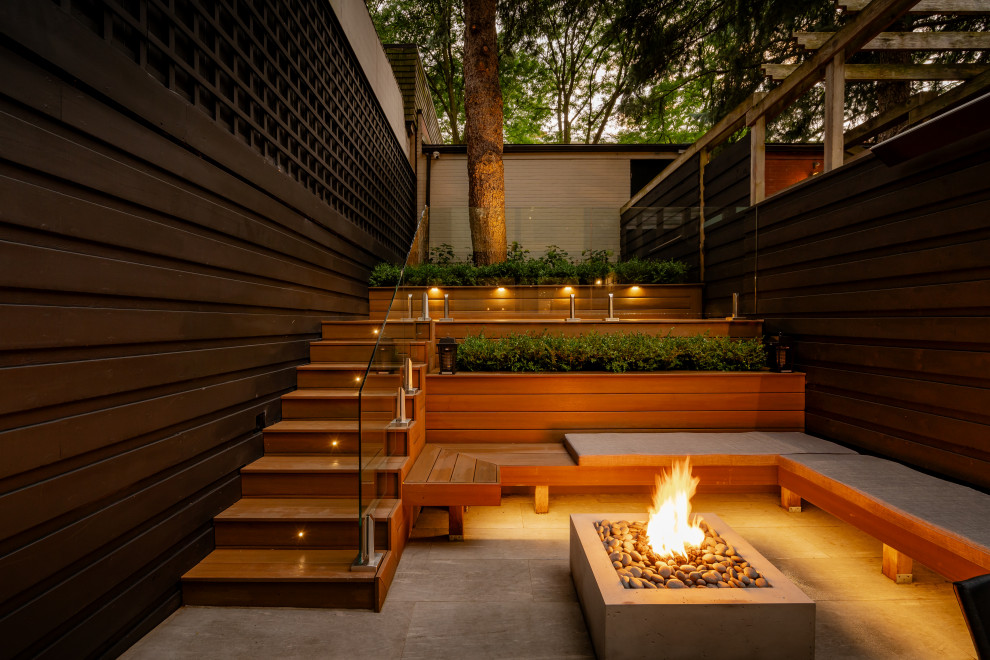 Kleiner, Unbedeckter Moderner Patio hinter dem Haus mit Feuerstelle und Betonboden in Toronto