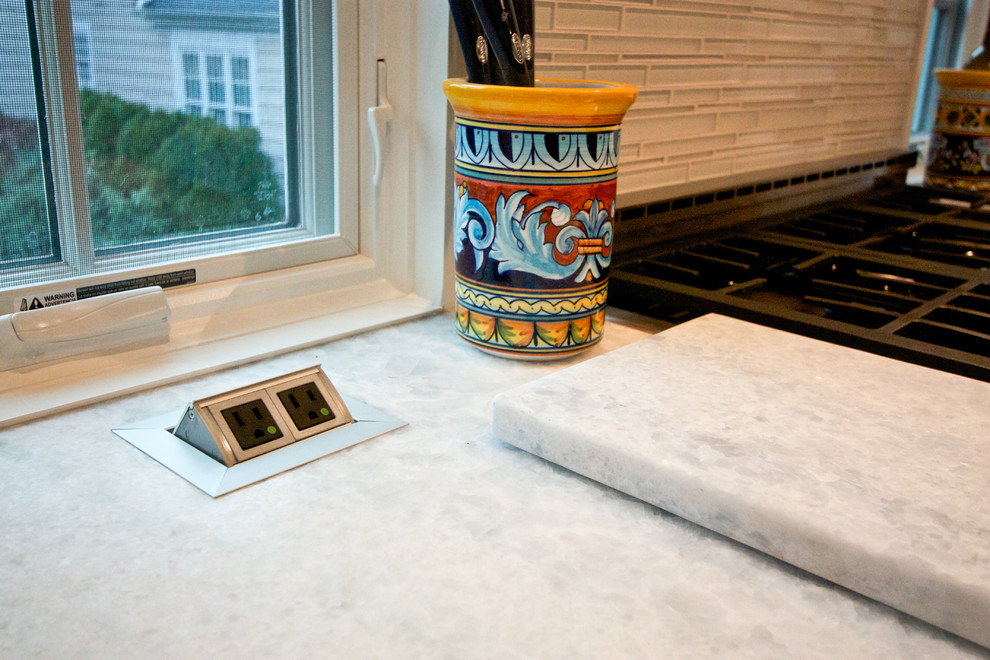 Example of a transitional light wood floor eat-in kitchen design in Newark with an undermount sink, recessed-panel cabinets, white cabinets, wood countertops, white backsplash, glass tile backsplash, stainless steel appliances and an island