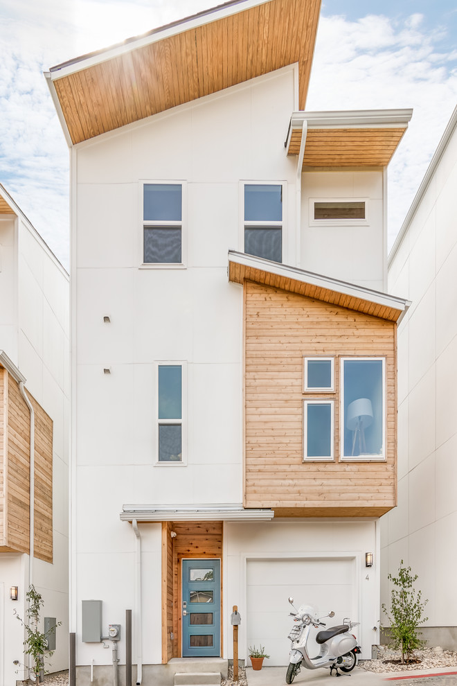 Contemporary three-storey white townhouse exterior in Austin with mixed siding and a shed roof.