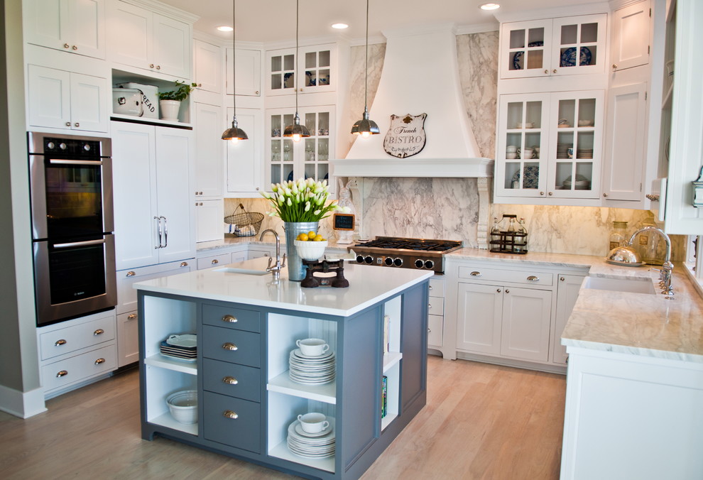 Beach style u-shaped kitchen in Seattle with panelled appliances, a farmhouse sink, glass-front cabinets, white cabinets, marble benchtops, white splashback and marble splashback.