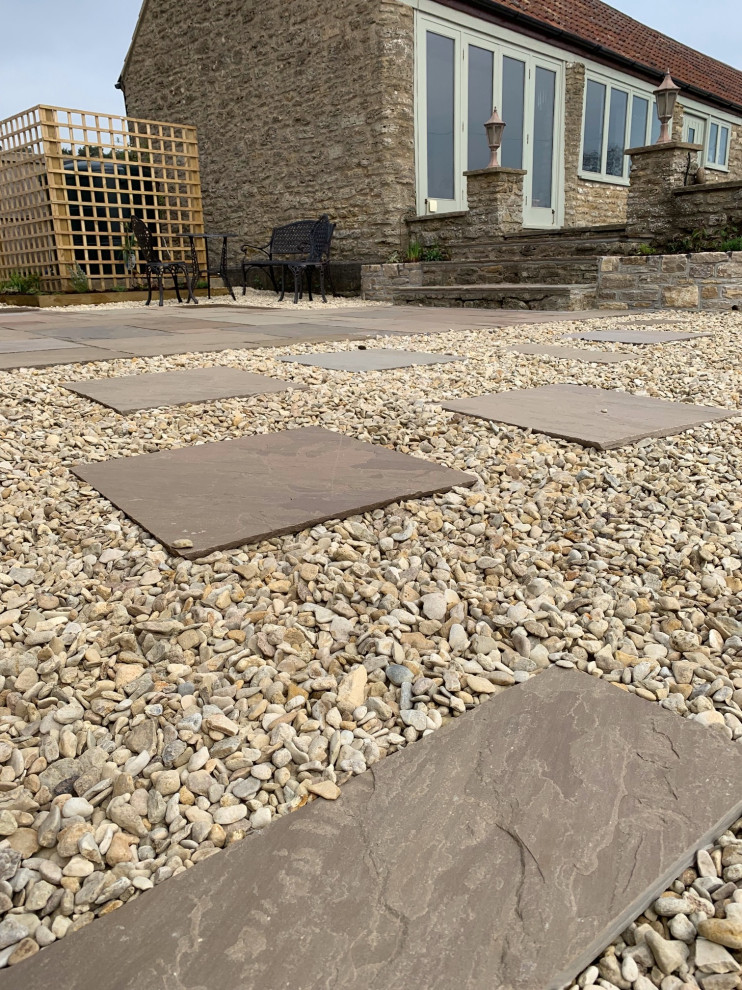 Photo of a medium sized country courtyard driveway full sun garden for summer in Other with decorative stones.