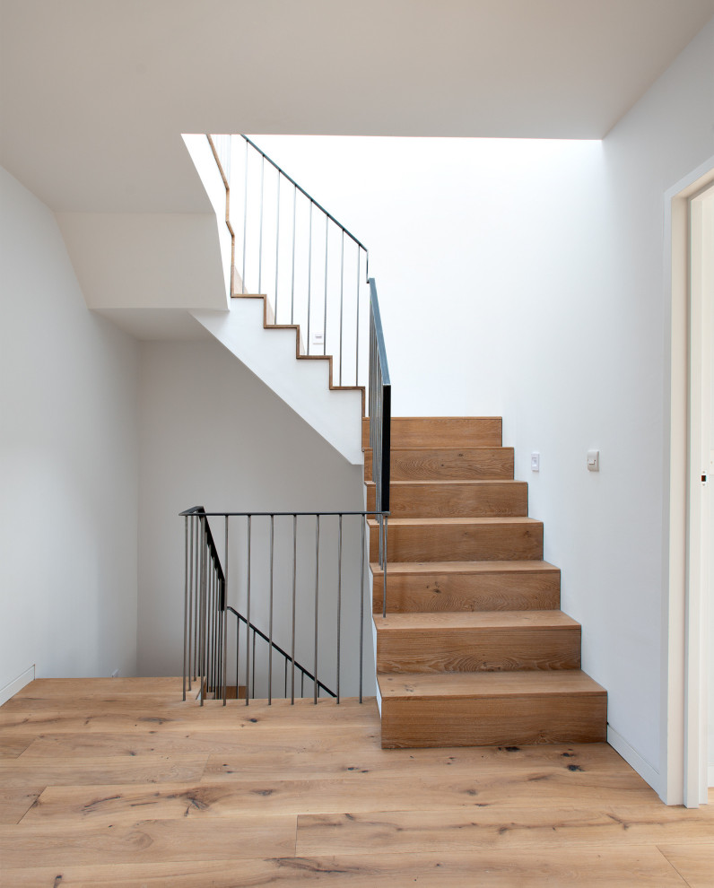 Exemple d'un escalier tendance de taille moyenne avec des marches en bois, des contremarches en bois et un garde-corps en métal.