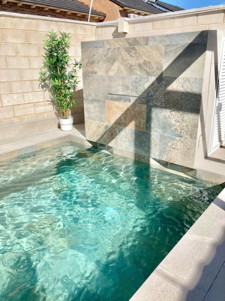 Ejemplo de casa de la piscina y piscina alargada moderna pequeña a medida en patio con suelo de baldosas