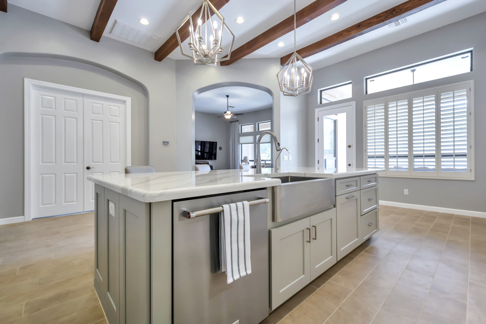 Inspiration for a large transitional l-shaped porcelain tile and brown floor eat-in kitchen remodel in Phoenix with a farmhouse sink, shaker cabinets, white cabinets, quartz countertops, white backsplash, subway tile backsplash, stainless steel appliances, an island and gray countertops