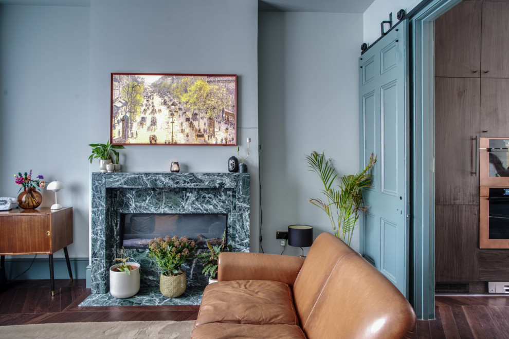 Mittelgroßes, Fernseherloses Modernes Wohnzimmer mit blauer Wandfarbe, Gaskamin, braunem Boden und Kaminumrandung aus Stein in Berkshire