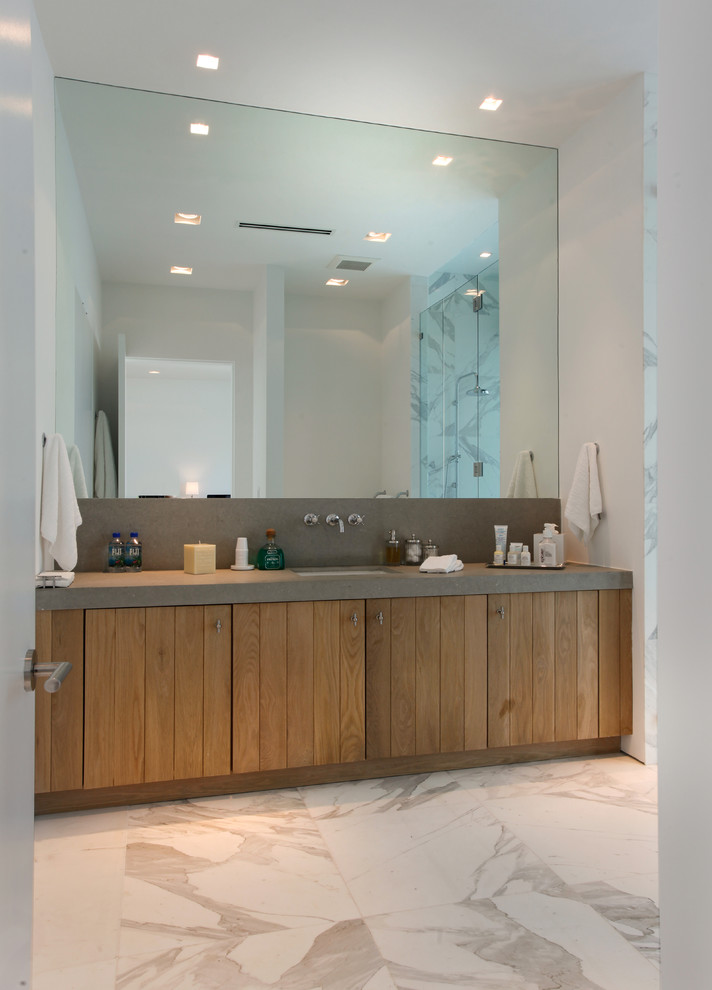 Photo of a mid-sized modern 3/4 bathroom in Miami with medium wood cabinets, white tile, stone tile, a drop-in sink, flat-panel cabinets, white walls, marble floors and limestone benchtops.