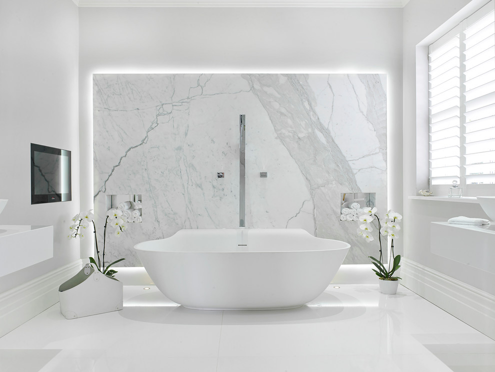 Large contemporary master bathroom in London with a freestanding tub, white tile, white walls, porcelain floors, a vessel sink, solid surface benchtops, white floor, white benchtops and marble.